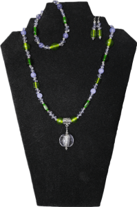 A demi-parure (set of three items) using upcycled and new beads. Upcycled glass and amethyst beads contrasting green and purple / matching bracelet and earrings (hypoallergenic wires)